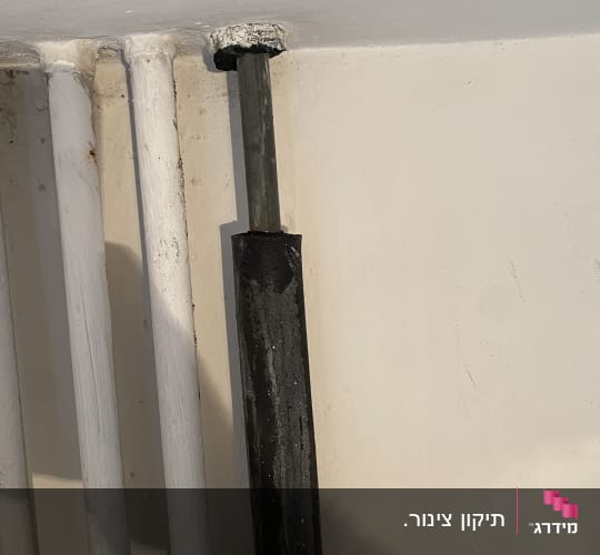 צינור מים מבודד ומצופה העובר בקיר פנימי